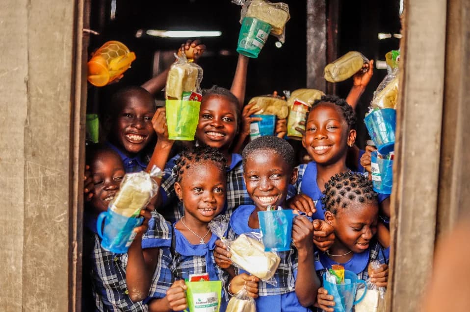 Enfants souriants d'un village recevant des fournitures